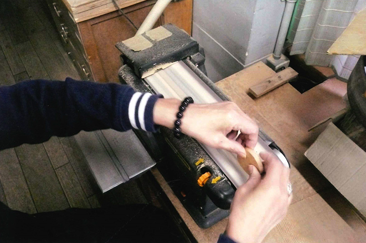 秋田杉の木片を磨き上げる、RiRiKOの手元のアップ写真